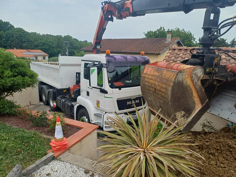 Camion grue livrant des matériaux dans une maison près de Toulouse